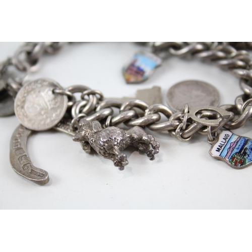 2077 - A silver charm bracelet with assorted charms - approx. gross weight 93g