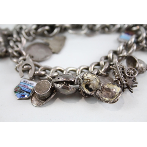 2077 - A silver charm bracelet with assorted charms - approx. gross weight 93g