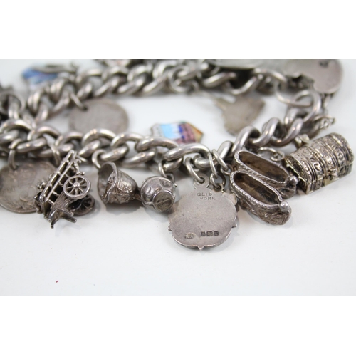 2077 - A silver charm bracelet with assorted charms - approx. gross weight 93g