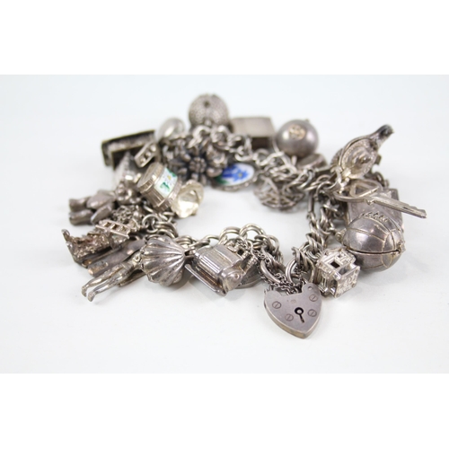 2080 - A vintage silver charm bracelet with assorted charms - approx. gross weight 99g