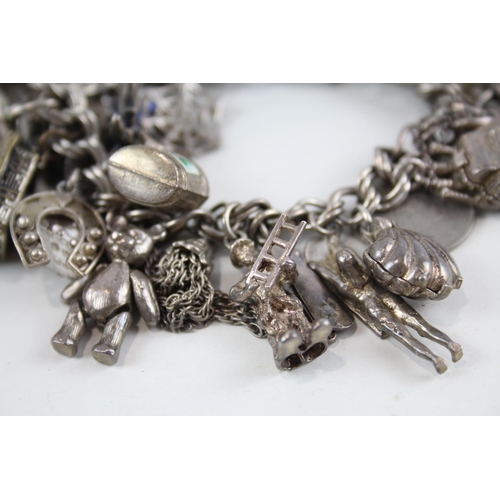 2080 - A vintage silver charm bracelet with assorted charms - approx. gross weight 99g