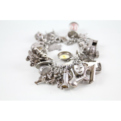 2090 - A silver charm bracelet with assorted charms - approx. gross weight 100g