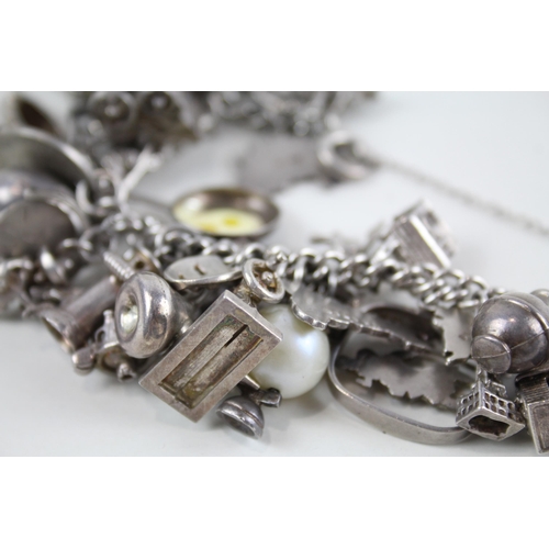 2090 - A silver charm bracelet with assorted charms - approx. gross weight 100g