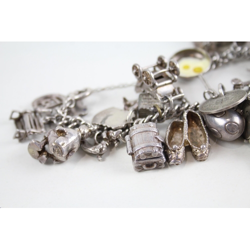 2090 - A silver charm bracelet with assorted charms - approx. gross weight 100g