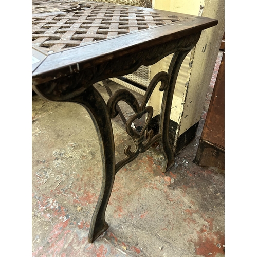 105 - A modern cast iron and wood garden table - approx. 66cm high x 57cm wide x 116cm long