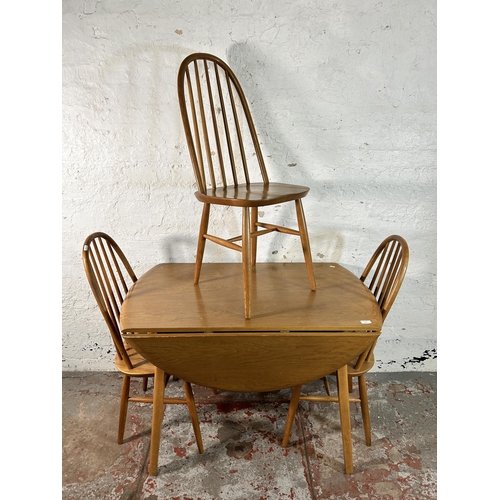 120 - An Ercol style elm and beech drop leaf oval dining table and three chairs