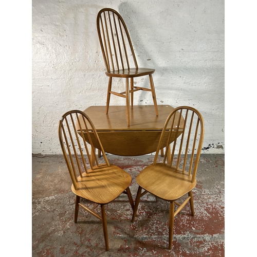 120 - An Ercol style elm and beech drop leaf oval dining table and three chairs