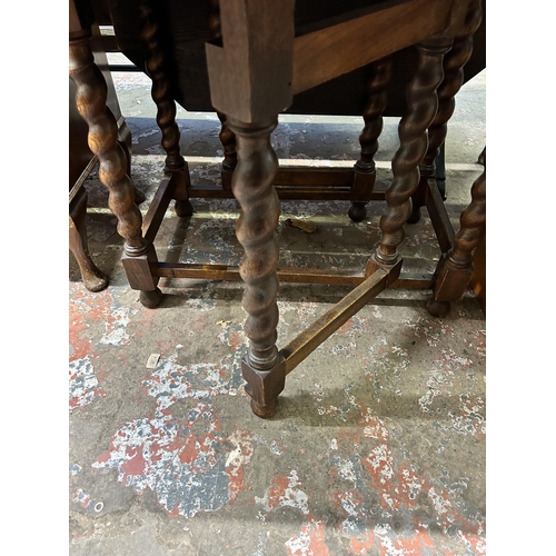 20 - An early 20th century oak drop leaf gate leg dining table on barley twist supports