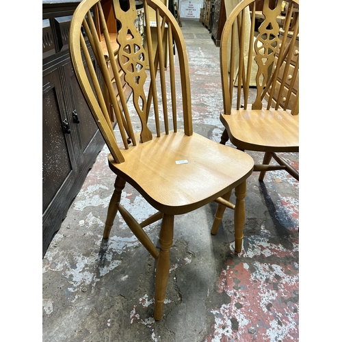 20A - A pair of beech wheel back dining chairs