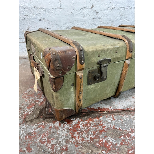 27 - An early 20th century green canvas and fibreboard travel trunk with beech and leather banding, stamp... 