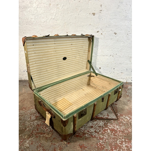 27 - An early 20th century green canvas and fibreboard travel trunk with beech and leather banding, stamp... 