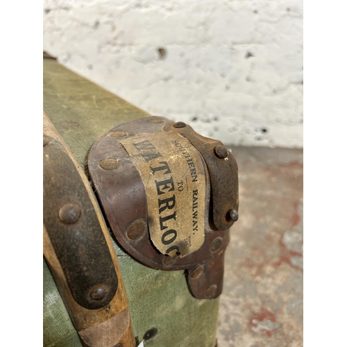 27 - An early 20th century green canvas and fibreboard travel trunk with beech and leather banding, stamp... 