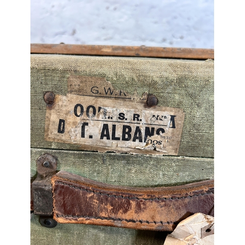 27 - An early 20th century green canvas and fibreboard travel trunk with beech and leather banding, stamp... 