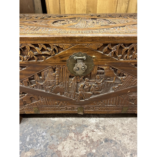 43 - A Chinese carved camphorwood and brass bound chest stamped 