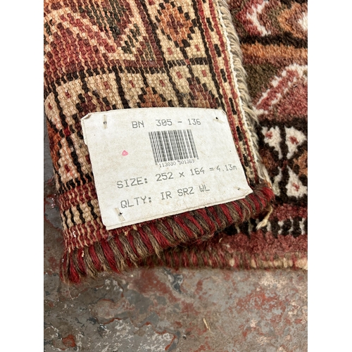 63 - A Persian style machine woven rug - approx. 252cm x 164cm