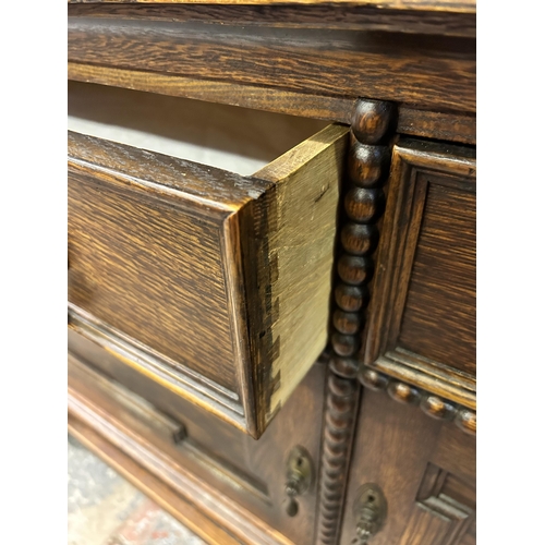 7 - A Jacobean style geometric carved oak dresser - approx. 190cm high x 152cm wide x 50cm deep