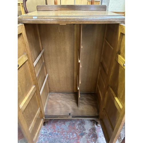 83 - An Art Deco style carved oak two door cabinet - approx. 138cm high x 76cm wide x 46cm deep