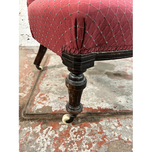 85A - A Victorian fabric upholstered button back nursing chair on turned mahogany supports and ceramic cas... 