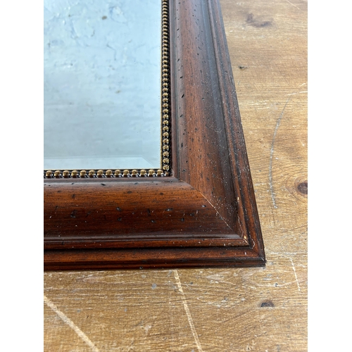 252 - A 19th century style mahogany and gilt framed bevelled edge wall mirror - approx. 75cm high x 106cm ... 