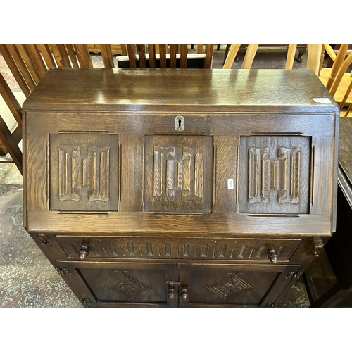 122 - A carved oak linenfold bureau - approx. 93cm high x 76cm wide x 42cm deep