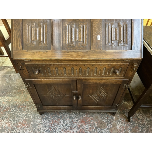 122 - A carved oak linenfold bureau - approx. 93cm high x 76cm wide x 42cm deep