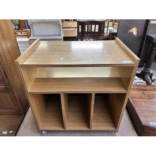 132 - A mid 20th century teak effect record cabinet on casters - approx. 61cm high x 58cm wide x 38cm deep