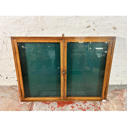 139 - An early 20th century oak two door glazed table top/wall mountable display case - approx. 77cxm high... 