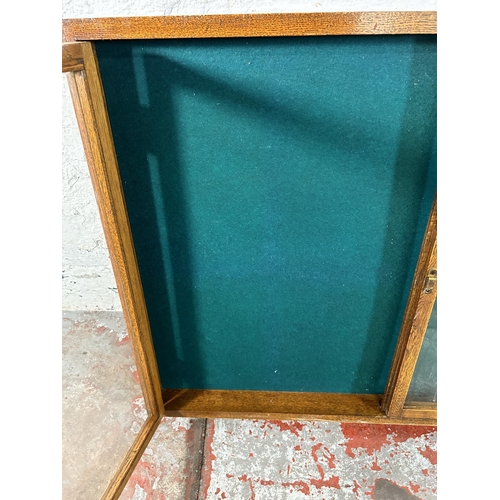 139 - An early 20th century oak two door glazed table top/wall mountable display case - approx. 77cxm high... 