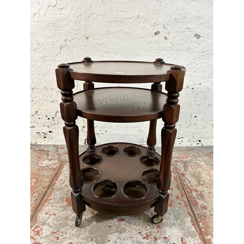 164 - An oak three tier drinks trolley - approx. 67cm high x 47cm diameter