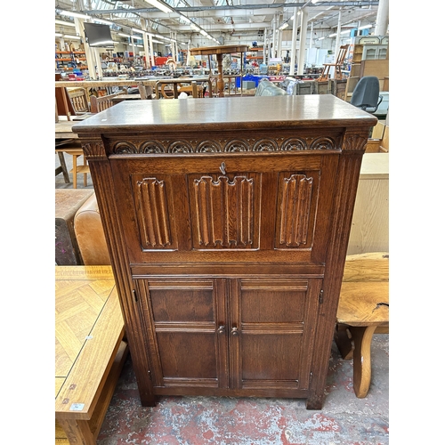 180 - A carved oak linenfold cocktail cabinet - approx. 123cm high x 80cm wide x 48cm deep