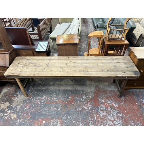 214 - An early 20th century pine trestle table - approx. 75cm high x 61cm wide x 243cm long