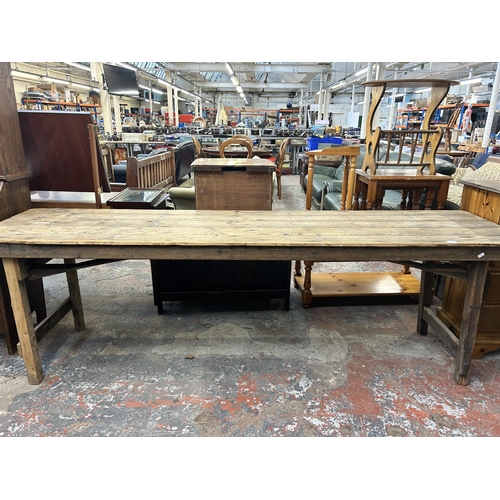 214 - An early 20th century pine trestle table - approx. 75cm high x 61cm wide x 243cm long