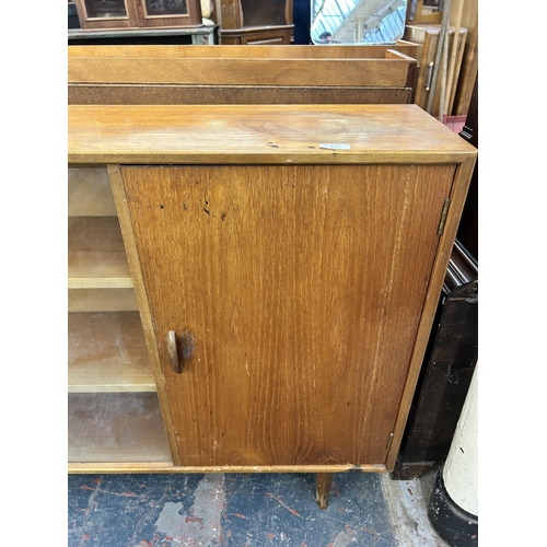 225 - A mid 20th century Herbert E. Gibbs teak bookcase with two glass sliding doors