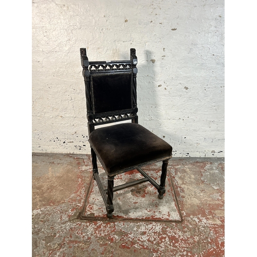 234 - A 19th century heavily carved and ebonised oak hall chair with black fabric upholstery