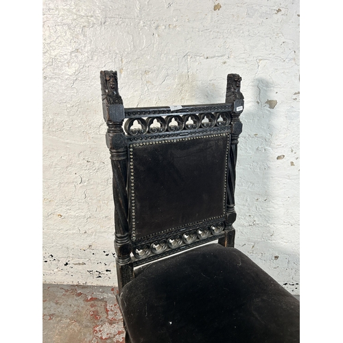 234 - A 19th century heavily carved and ebonised oak hall chair with black fabric upholstery