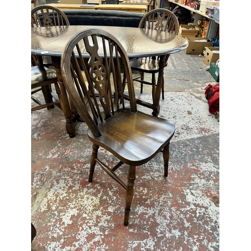 242 - An oak drop leaf gate leg dining table and four beech wheel back dining chairs