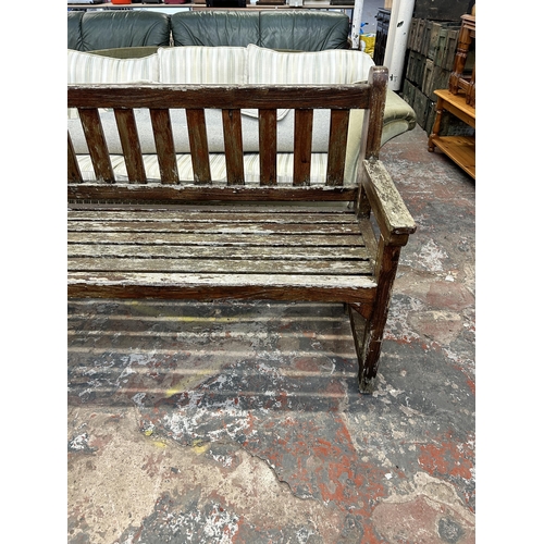 245 - A teak garden bench - approx. 90cm high x 151cm wide x 56cm deep