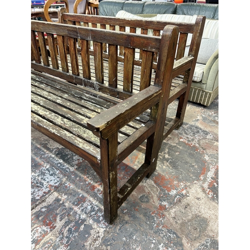 246 - A teak garden bench - approx. 90cm high x 151cm wide x 56cm deep