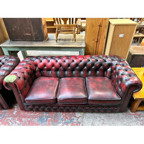 183 - An oxblood leather three seater Chesterfield sofa