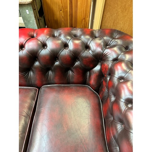 183 - An oxblood leather three seater Chesterfield sofa