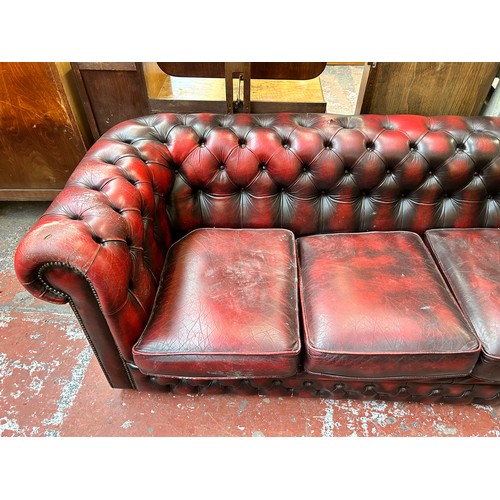 184 - An oxblood leather three seater Chesterfield sofa