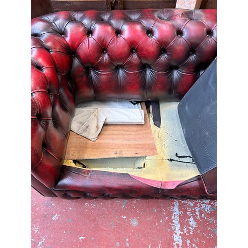 184 - An oxblood leather three seater Chesterfield sofa