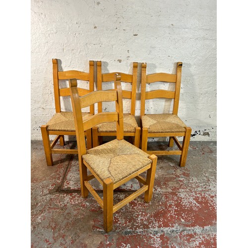 185 - Four beech and rush seated ladder back dining chairs