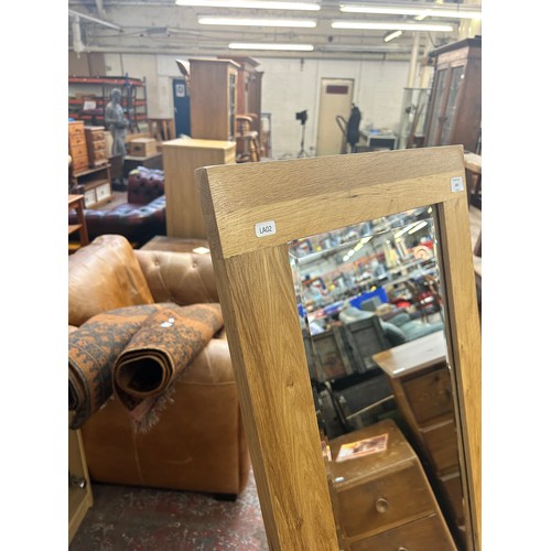 206 - A modern oak framed bevelled edge cheval mirror - approx. 144cm high x 48cm wide