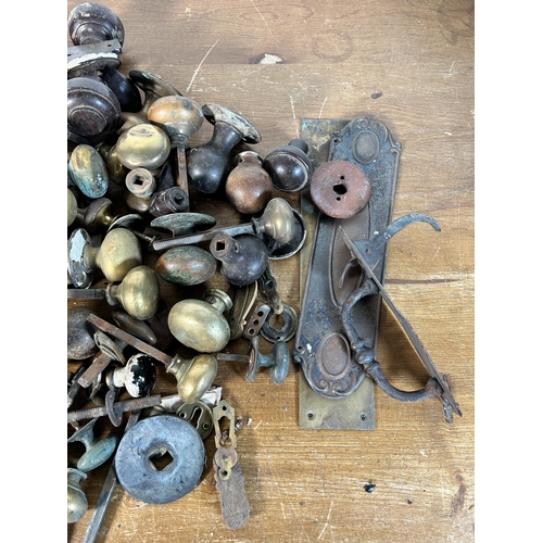 622 - A collection of antique metal door fixtures and fittings comprising Art Nouveau knocker, knobs, lock... 