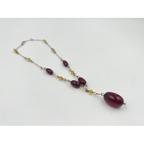 2002 - An Art Deco cherry amber Bakelite beaded and yellow metal necklace - approx. gross weight 7.8g