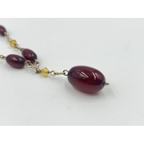 2002 - An Art Deco cherry amber Bakelite beaded and yellow metal necklace - approx. gross weight 7.8g