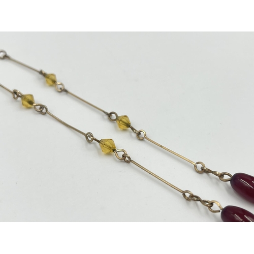 2002 - An Art Deco cherry amber Bakelite beaded and yellow metal necklace - approx. gross weight 7.8g