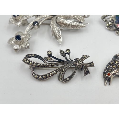 2019 - Four silver brooches to include marcasite set dolphin, sapphire set floral etc. - approx. gross weig... 