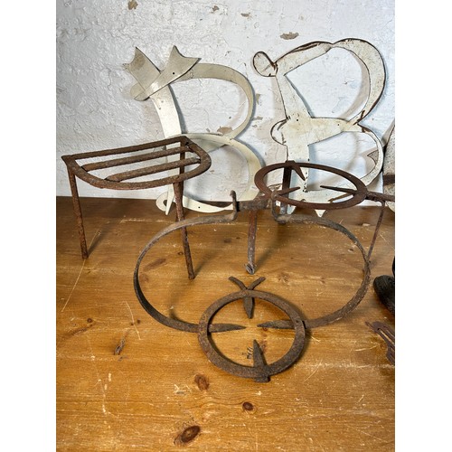 629 - A collection of antique and later metalware to include cast iron drain hopper, trivet stands, flat i... 